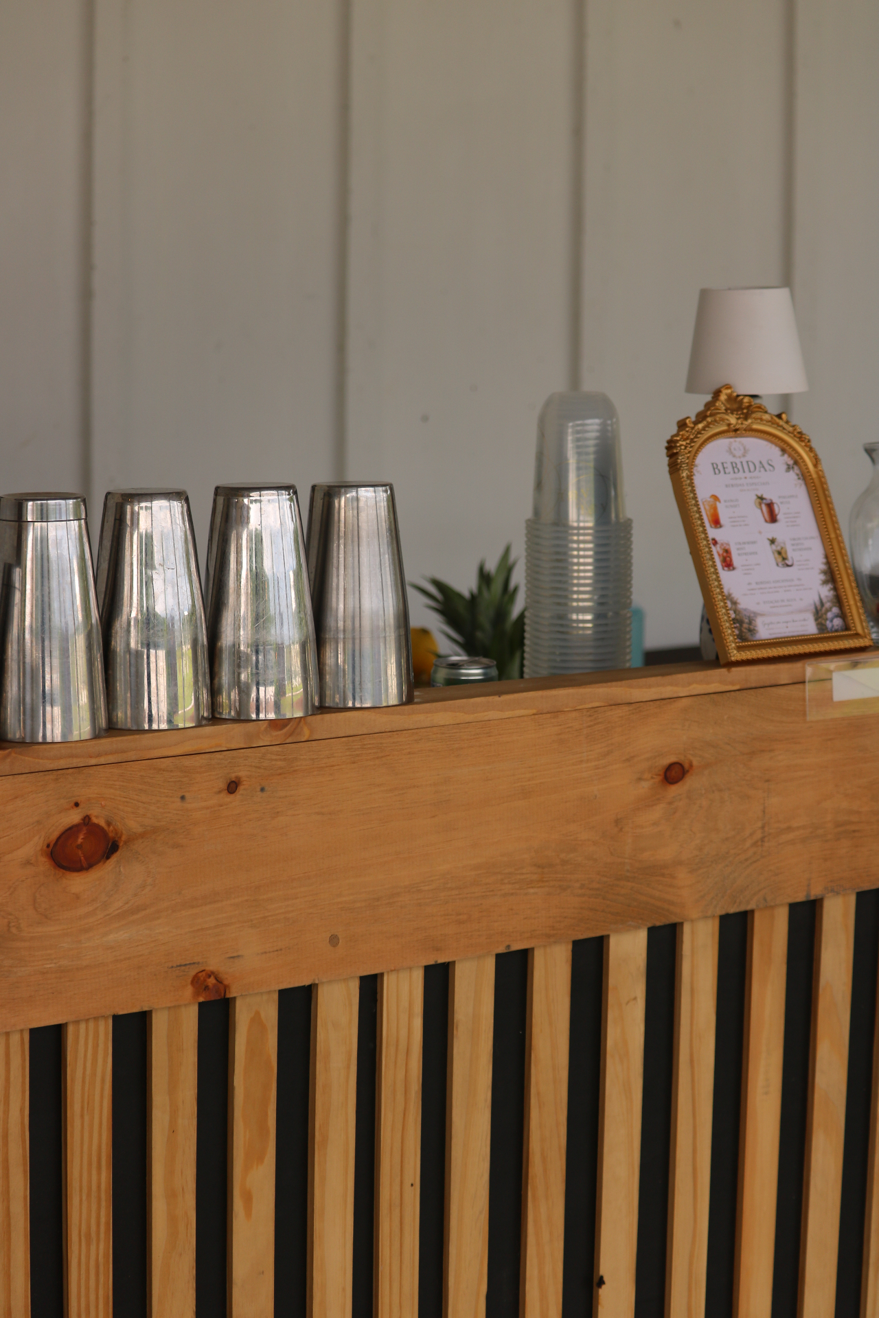 Dos Santos wooden mobile bar stand with shakers and a framed bebidas menu