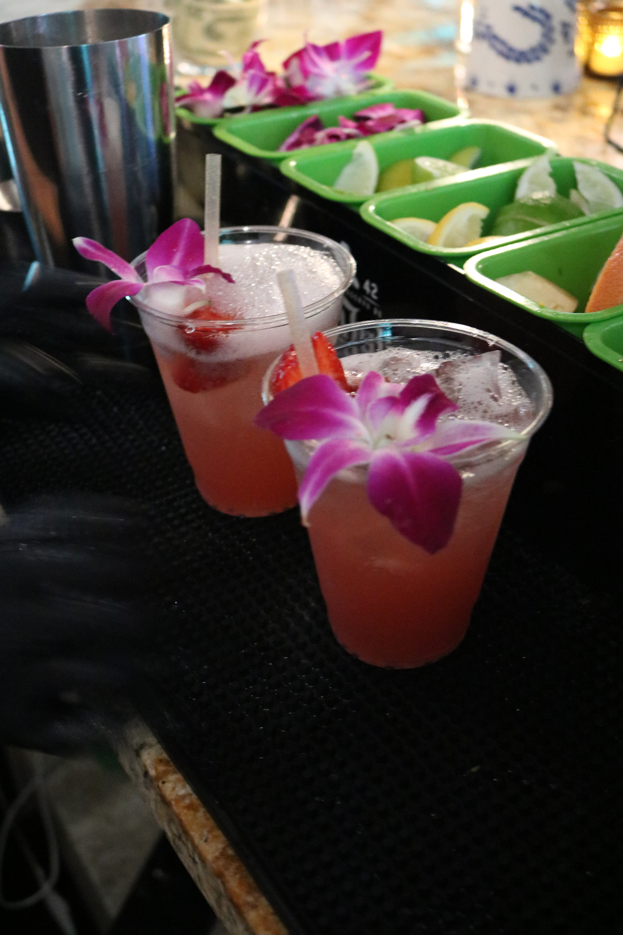 Two orchid-garnished strawberry cocktails on the bar mat